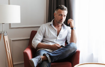 handsome attractive man in shirt sitting on chair